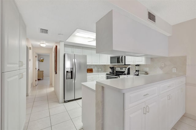 kitchen featuring white cabinetry, appliances with stainless steel finishes, light tile patterned flooring, and tasteful backsplash