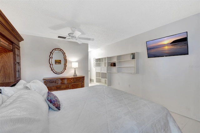 bedroom with ceiling fan and a textured ceiling