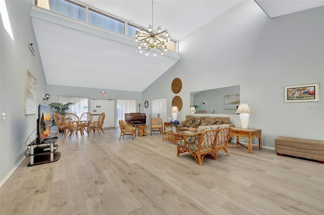 living room featuring a high ceiling, a notable chandelier, and light hardwood / wood-style flooring