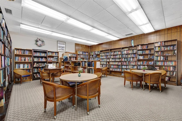 interior space with light colored carpet and wood walls