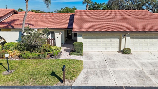 ranch-style house with a garage and a front lawn