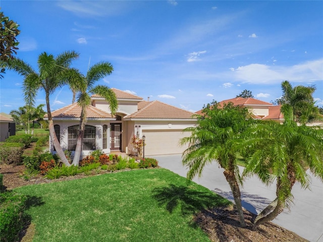 mediterranean / spanish house featuring a garage and a front lawn