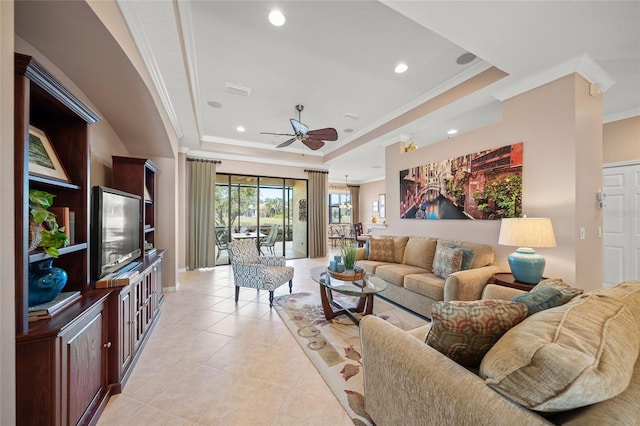 living room with light tile patterned floors, ornamental molding, a raised ceiling, and ceiling fan