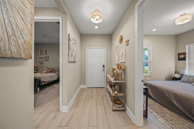 entrance foyer with light hardwood / wood-style floors and a textured ceiling