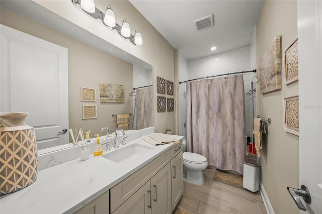 full bathroom featuring vanity, shower / bath combination with curtain, a textured ceiling, and toilet