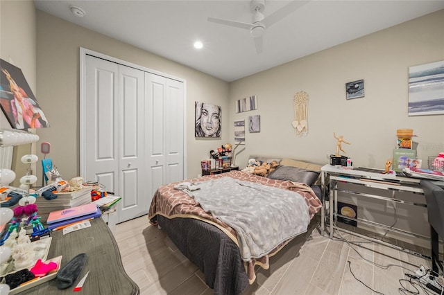 bedroom with ceiling fan, a closet, and light hardwood / wood-style flooring