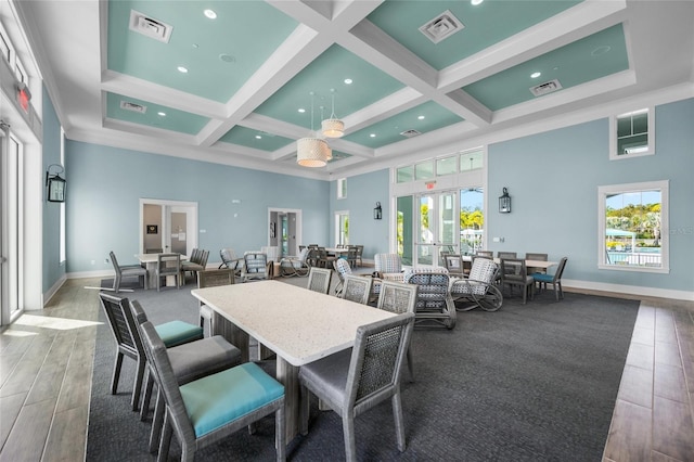 dining space with a towering ceiling, beam ceiling, coffered ceiling, a wealth of natural light, and french doors