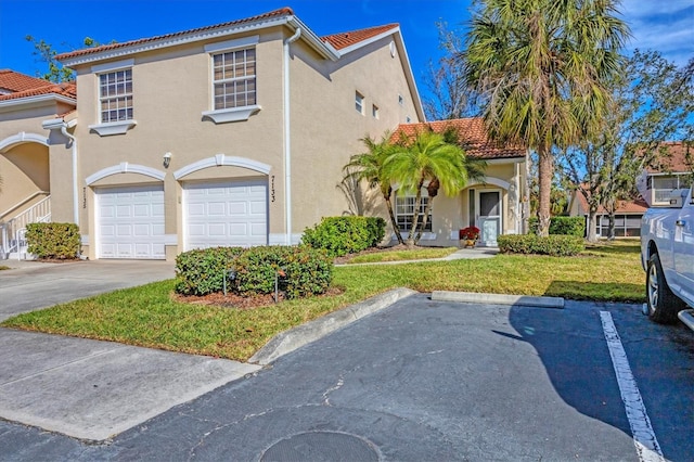 mediterranean / spanish home with a garage and a front yard