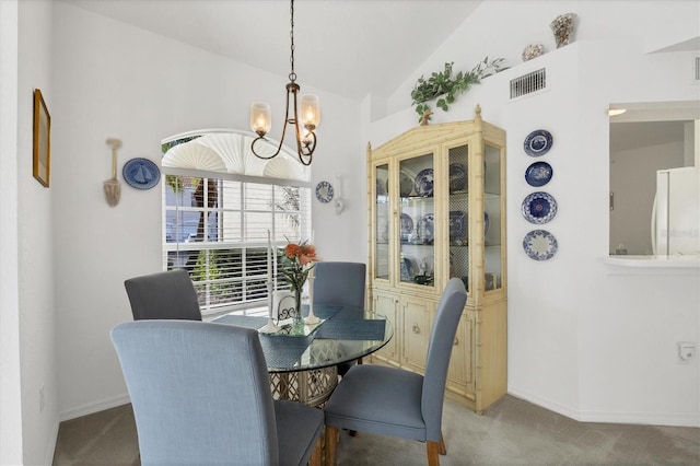 dining area with lofted ceiling, a chandelier, and carpet