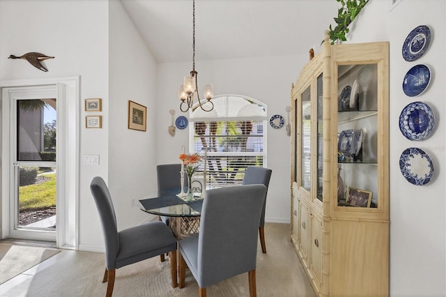 carpeted dining space featuring lofted ceiling and a chandelier