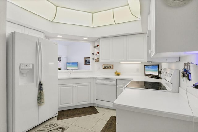 kitchen with white appliances, kitchen peninsula, white cabinets, and light tile patterned flooring