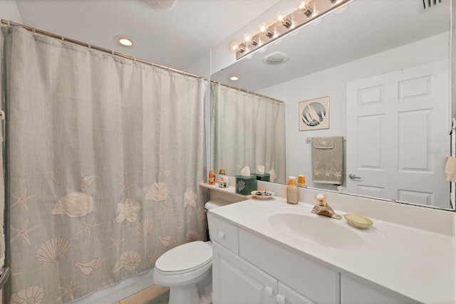 bathroom with vanity, curtained shower, a textured ceiling, and toilet