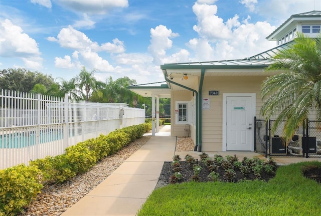 view of exterior entry with a fenced in pool