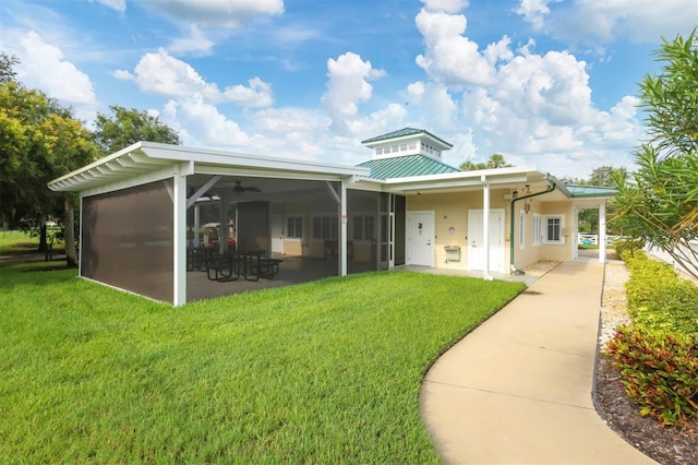 rear view of property with a lawn, a sunroom, and a patio