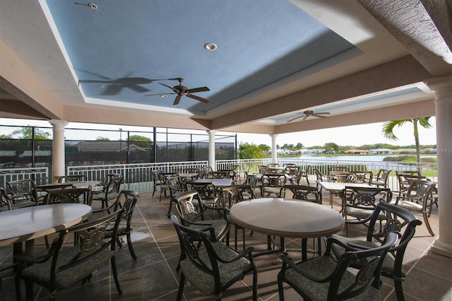 view of patio with a water view and ceiling fan