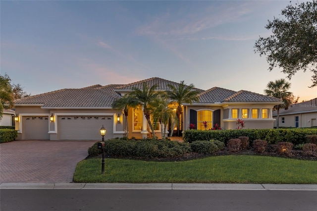 mediterranean / spanish-style house featuring a yard and a garage