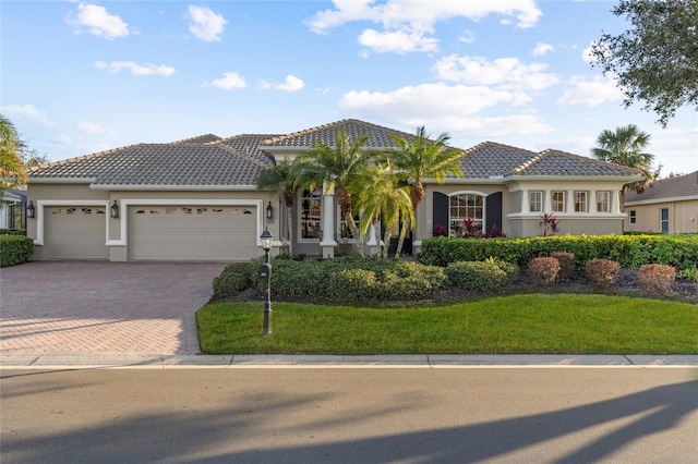 mediterranean / spanish-style home with a garage and a front lawn