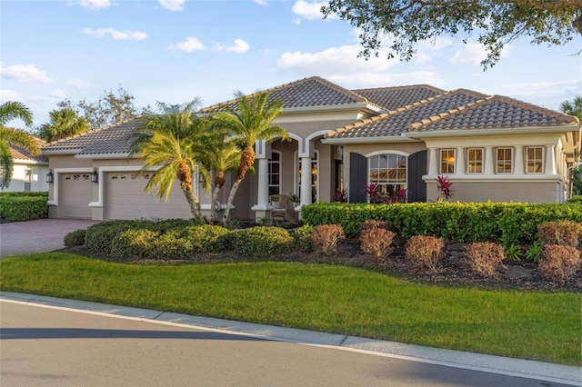 mediterranean / spanish-style home featuring a garage and a front yard