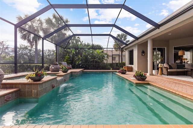 view of pool with a lanai, a patio area, and pool water feature