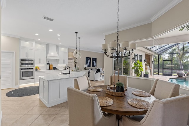 dining room with ornamental molding, a chandelier, sink, and light tile patterned floors