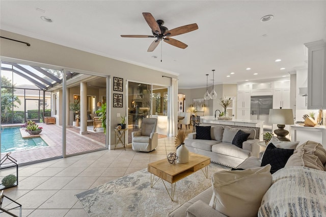 living room with light tile patterned floors, crown molding, and ceiling fan