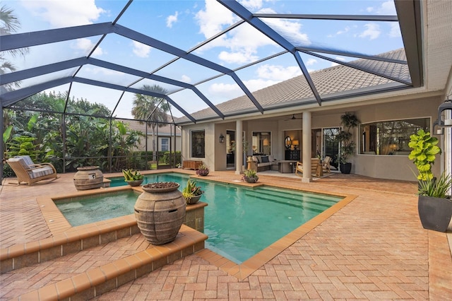 view of swimming pool featuring a patio area, an in ground hot tub, ceiling fan, and glass enclosure