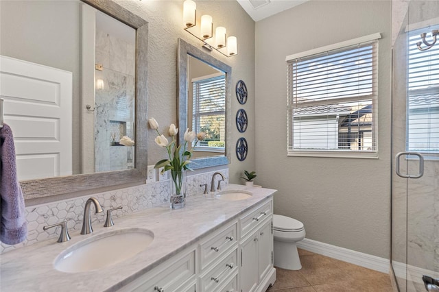 bathroom featuring tile patterned flooring, vanity, toilet, and a shower with shower door