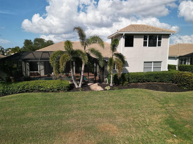 view of front facade with a front yard and glass enclosure