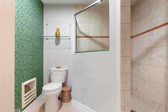 bathroom with a tile shower, tile patterned flooring, and toilet