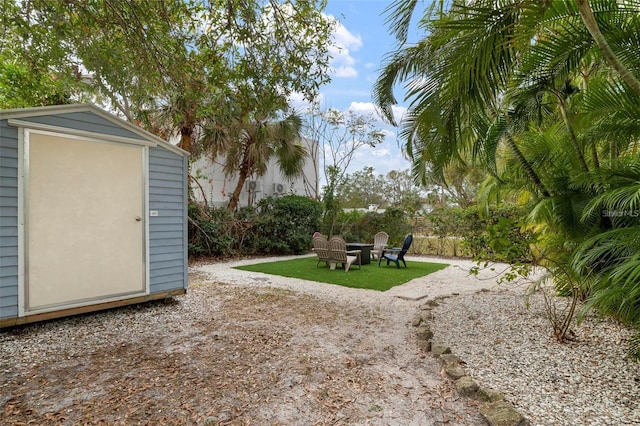 view of yard featuring a shed and an outdoor fire pit