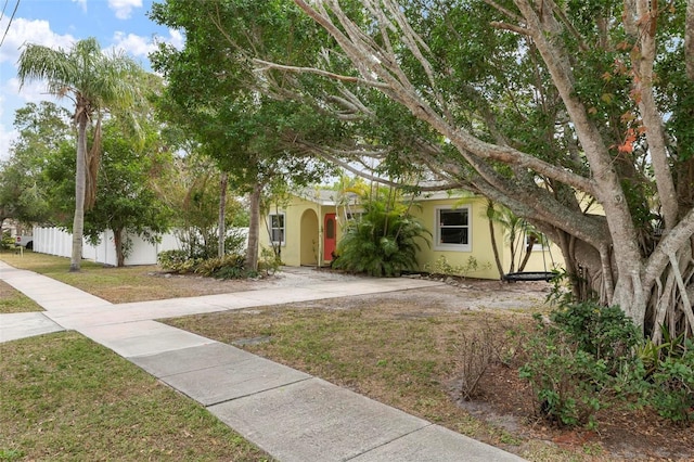 view of property hidden behind natural elements featuring a front yard