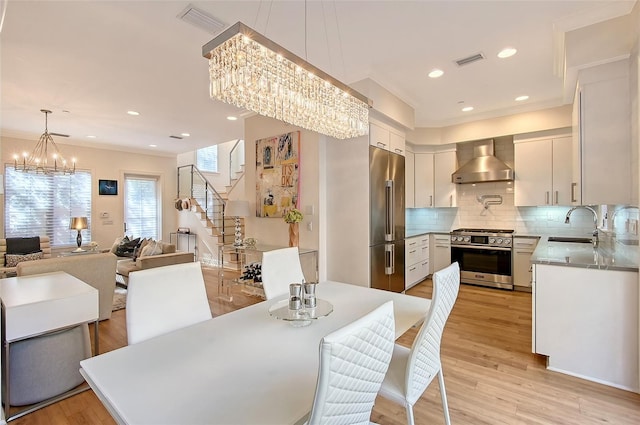 dining room with a chandelier, sink, and light hardwood / wood-style flooring