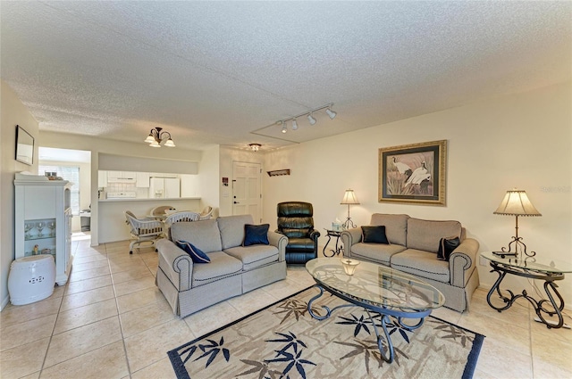 living room with light tile patterned floors, track lighting, and a textured ceiling