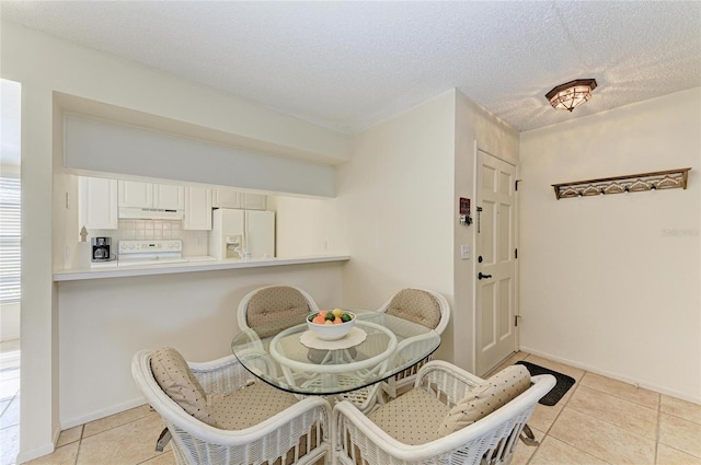 tiled dining space with a textured ceiling