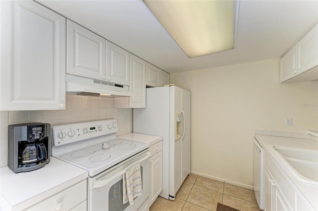 kitchen with light tile patterned flooring, tasteful backsplash, sink, white cabinets, and white appliances