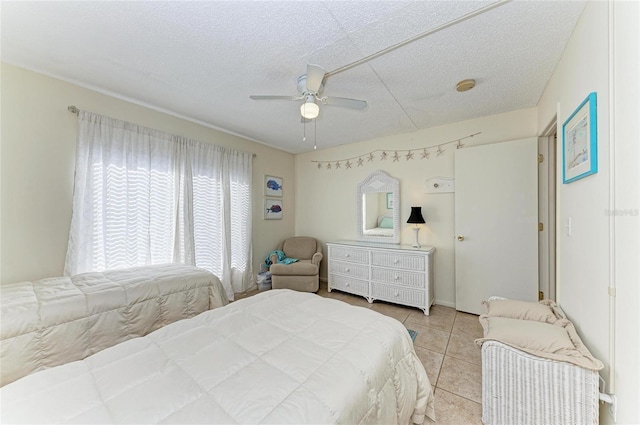 bedroom featuring ceiling fan, a textured ceiling, and light tile patterned floors