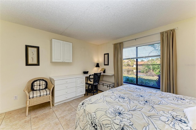 tiled bedroom with built in desk and a textured ceiling