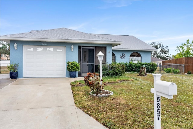 single story home featuring a garage and a front lawn