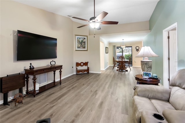 living room with ceiling fan, lofted ceiling, and light wood-type flooring