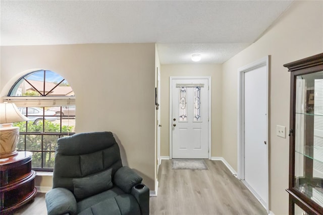 entrance foyer with light hardwood / wood-style floors and a textured ceiling