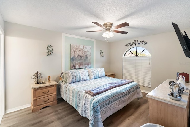 bedroom featuring ceiling fan, dark wood-type flooring, and a textured ceiling