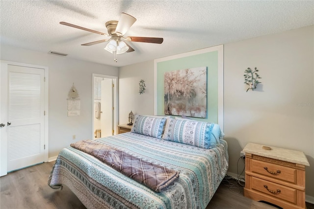 bedroom with ceiling fan, hardwood / wood-style flooring, a textured ceiling, and ensuite bathroom