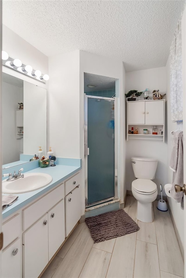 bathroom with vanity, an enclosed shower, and a textured ceiling