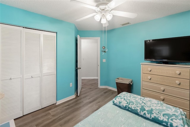 bedroom featuring ceiling fan, a textured ceiling, light wood-type flooring, and a closet