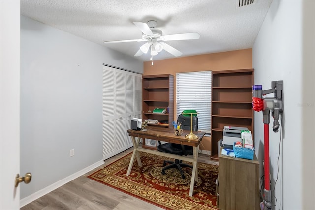 office featuring ceiling fan, hardwood / wood-style floors, and a textured ceiling