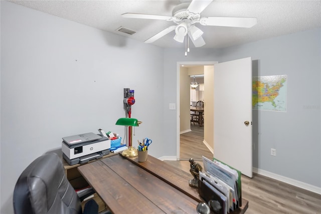 home office with ceiling fan, wood-type flooring, and a textured ceiling