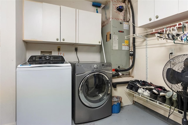 clothes washing area featuring cabinets and washing machine and clothes dryer