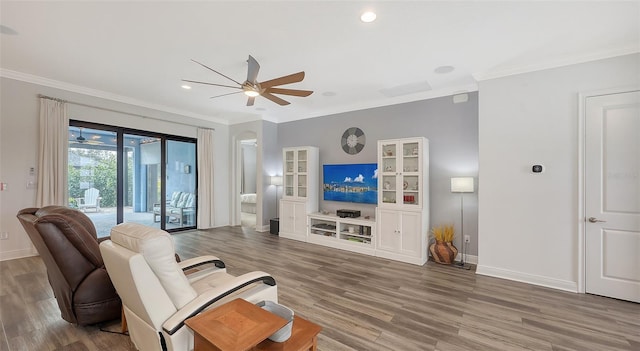 living room with hardwood / wood-style floors, ornamental molding, and ceiling fan