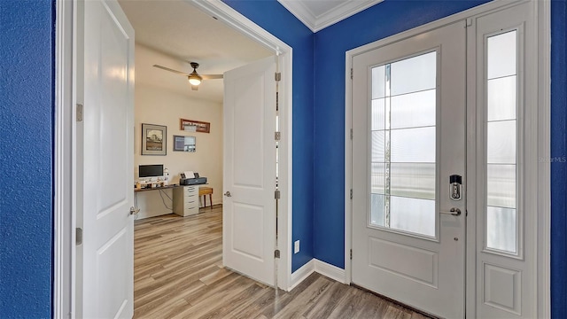 doorway featuring crown molding, built in desk, light hardwood / wood-style floors, and a healthy amount of sunlight