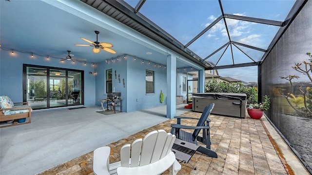 view of patio / terrace featuring a hot tub and a lanai